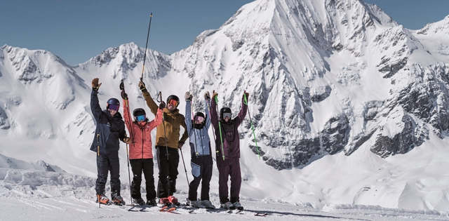 Jubelnde Skifahrer vor Bergpanorama