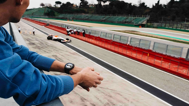 Tudor Black Bay Chrono Carbon 25 am Handgelenk vor Rennstrecke