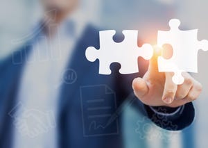 Mergers and acquisition concept with consultant touching icons of puzzle pieces representing the merging of two companies or joint venture.