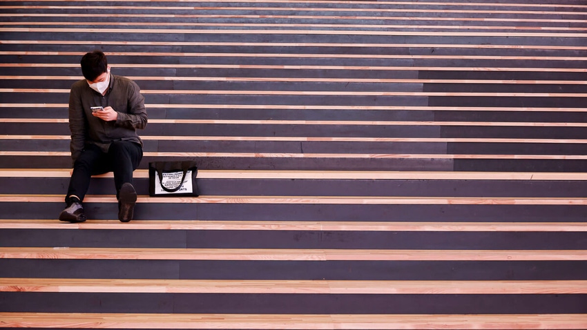 A person using a smartphone while sitting on the stairs in South Korea