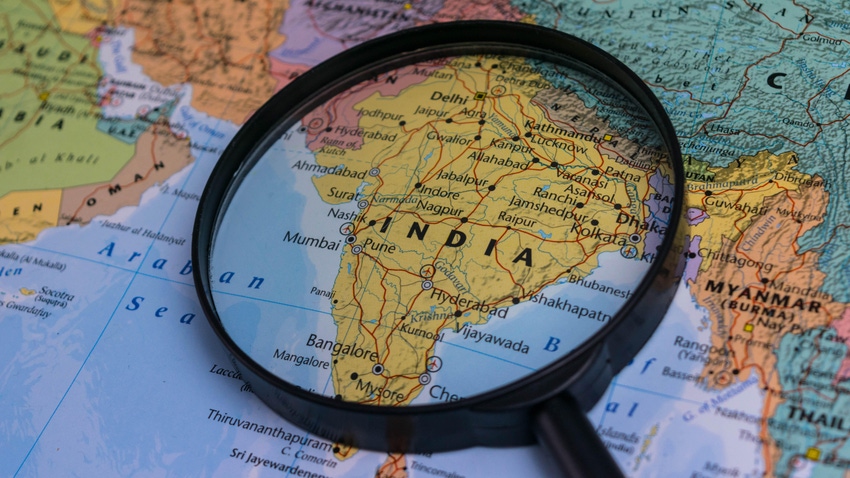 India map through magnifying glass on a world map