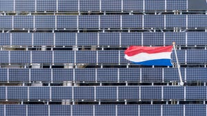 Dutch flag flying over an array of solar panels