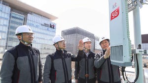 KT Corp employees and the CEO Hwang Chang-gyu look at 5G infrastructure they have set up in downtown Seoul