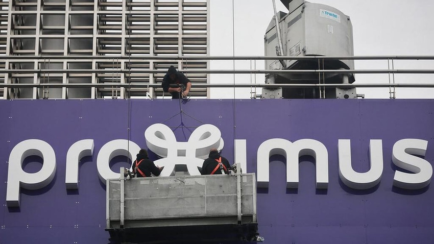 Workers putting Proximus sign on building