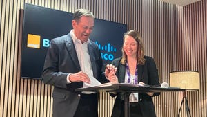 Orange Business CEO Aliette Mousnier-Lompré, and Cisco's Chair and CEO Chuck Robbins sign the MoU.