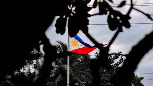 Flag of the Philippines in Manila, seen through foliage