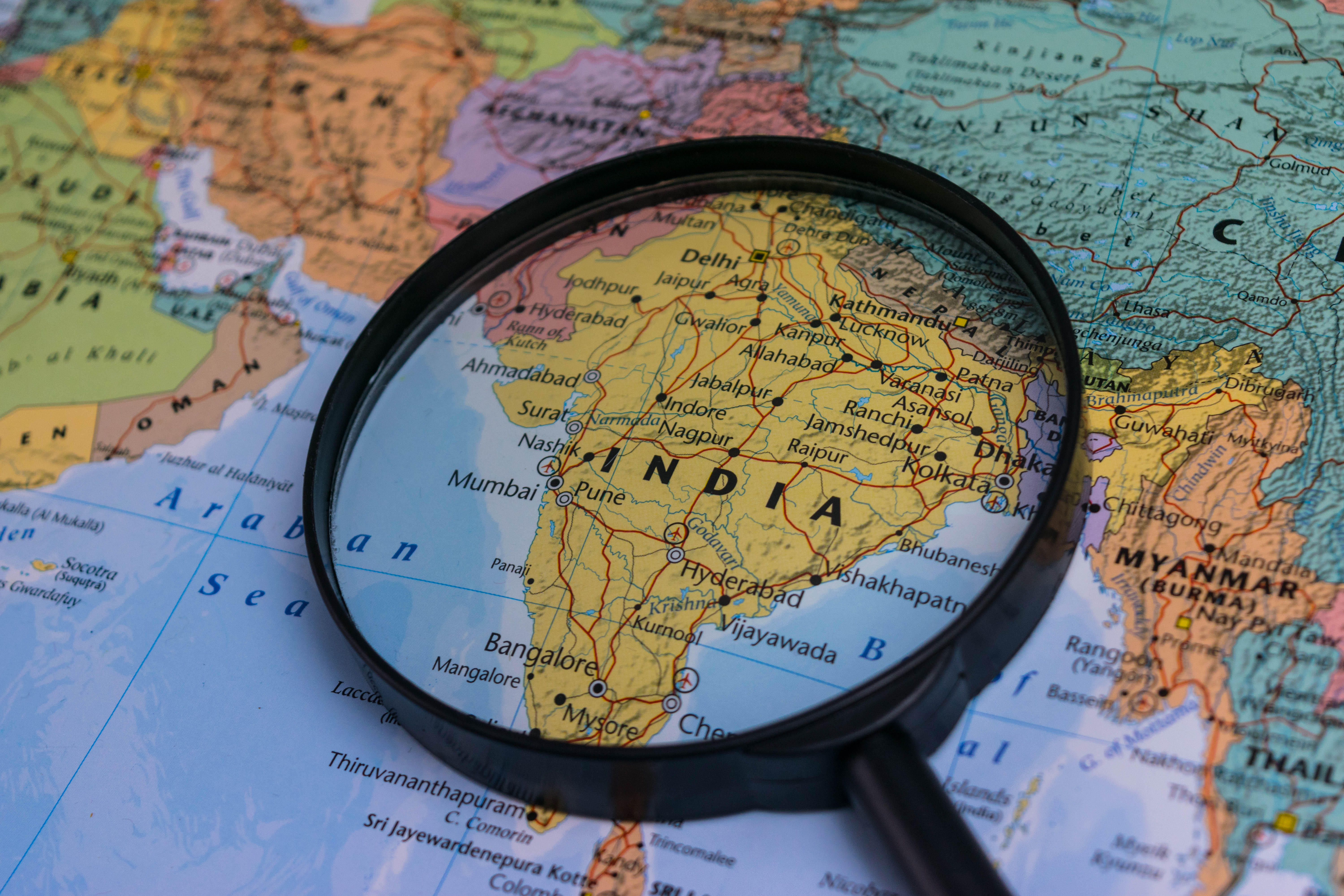 India map through magnifying glass on a world map