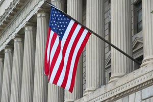 An American flag waves outside the US Department of Commerce building in Washington DC. The Commerce Dept. houses the NTIA