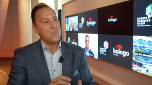 Boingo's Mike Zeto talks about the company's new innovation center in front of a wall of monitors. 