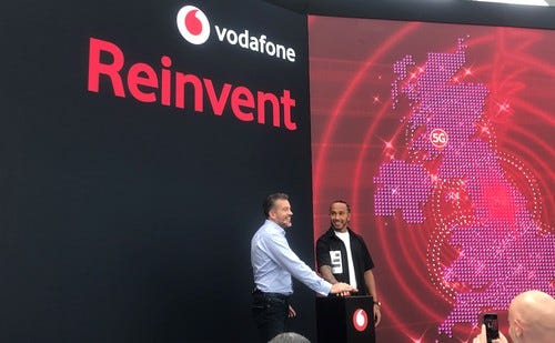 Vodafone CEO Nick Jeffery (left) and Formula 1 race car driver Lewis Hamilton hit the button.