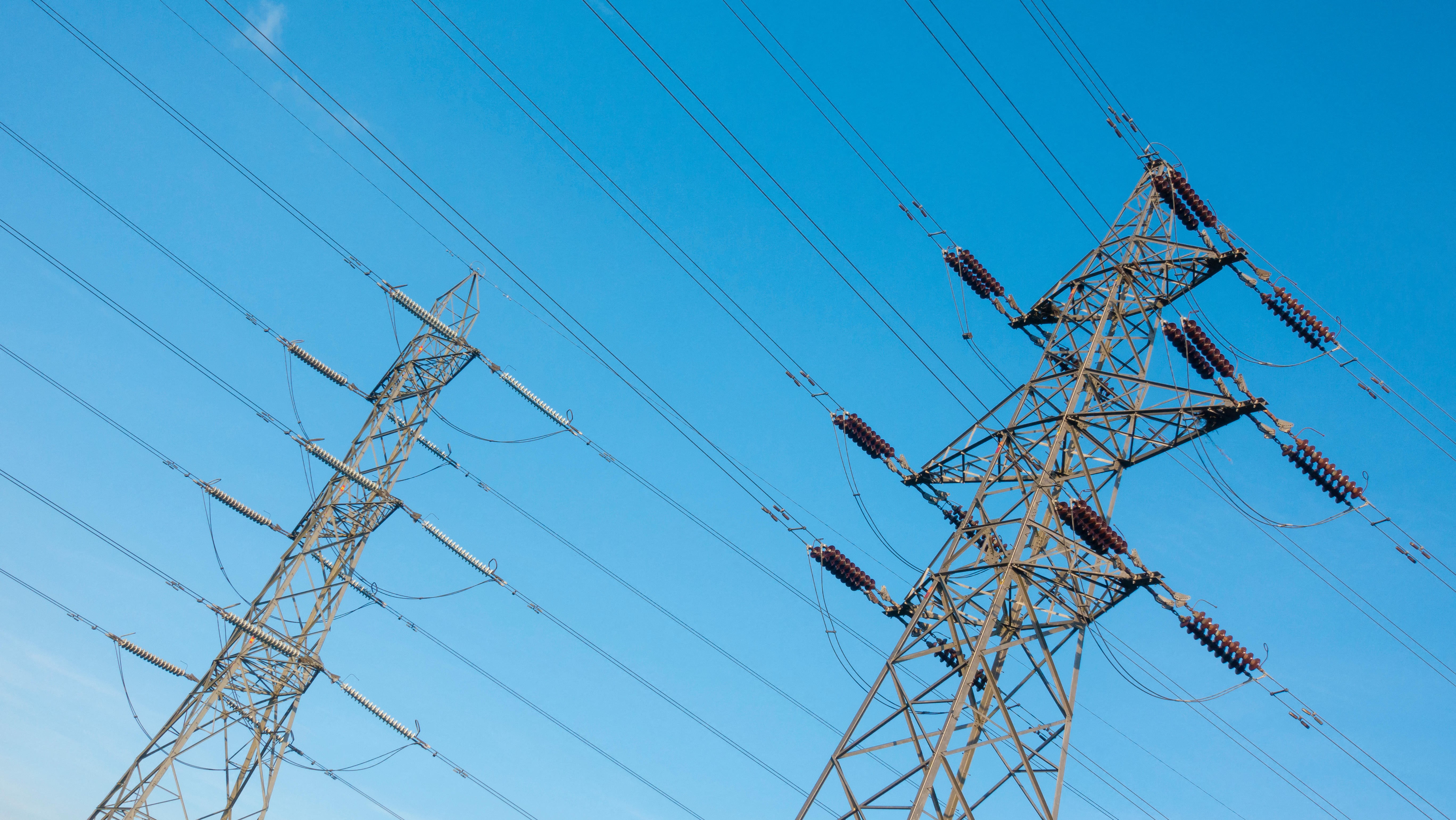 Electricity pylons against a blue sky