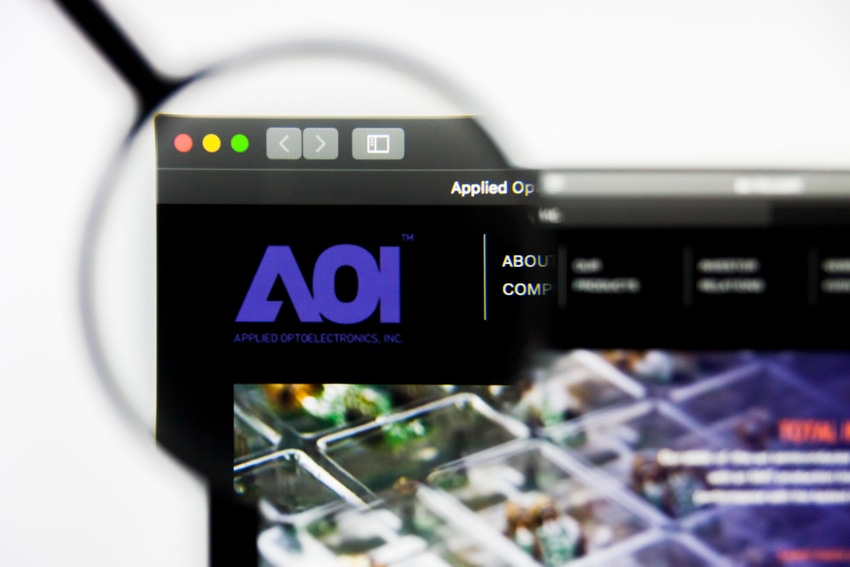 Applied Optoelectronics AOI logo shown on a computer screen through a magnifying glass