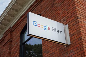 Google Fiber sign hanging off a brick building.