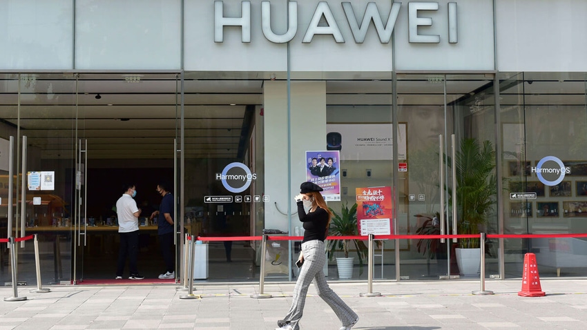 Woman passing by a Huawei shop in China.