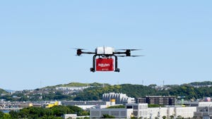A Rakuten drone flying above buildings
