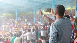 Spectators in stadium filming video on their smartphones Spectators in stadium filming video on their smartphones