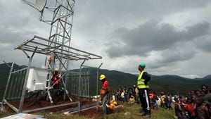Technicians erecting a mast