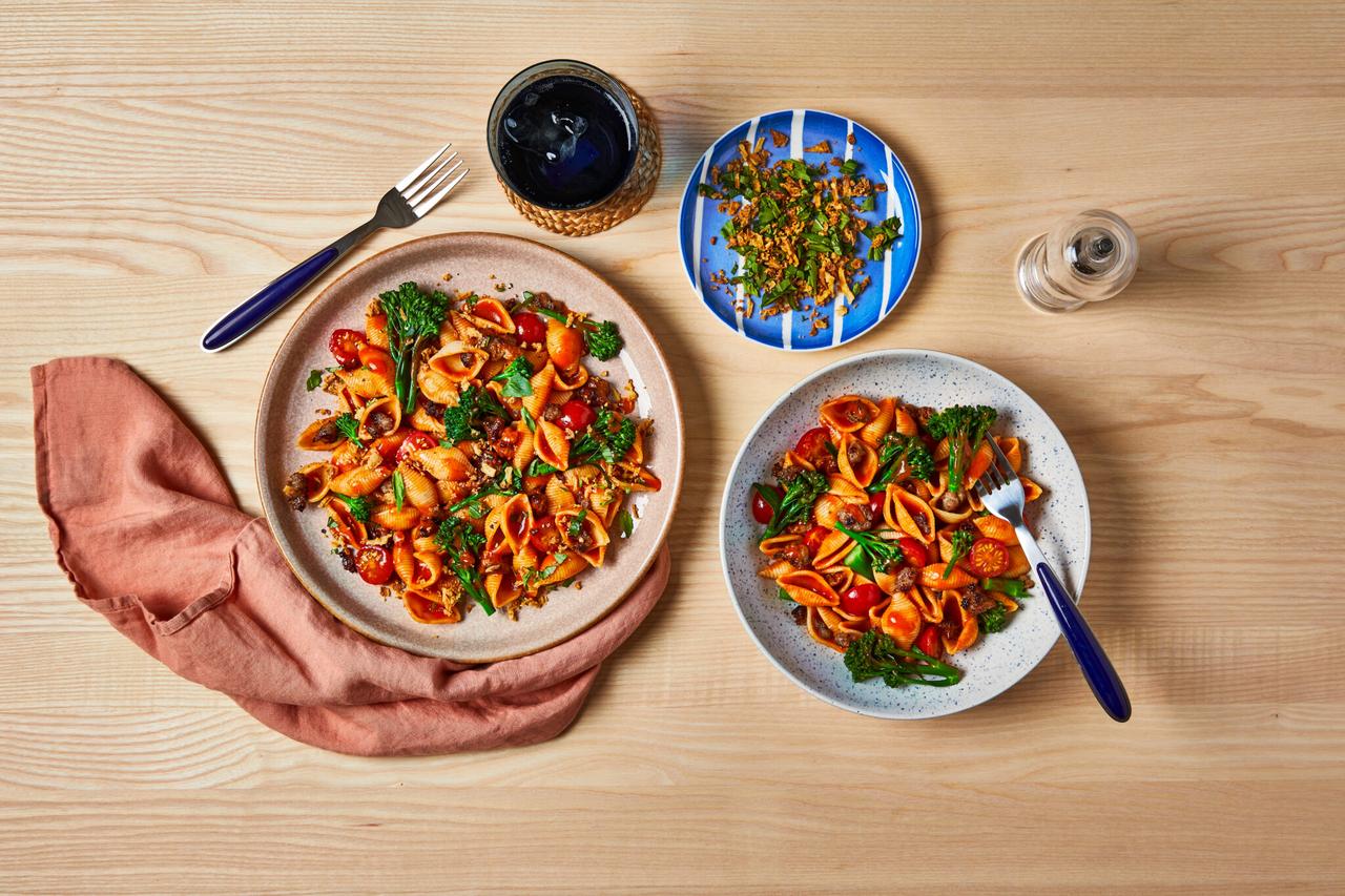 Two servings of the creamy chicken and sweetcorn pasta bake on a big plate and in a small bowl, modified for parent and child.