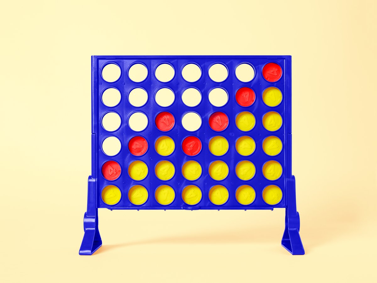 The game Connect Four, with an upward trend made with red checkers on a yellow background.