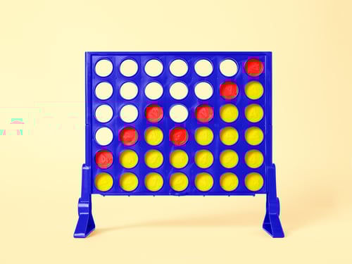 The game Connect Four, with an upward trend made with red checkers on a yellow background.