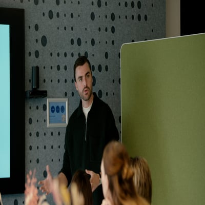 Een man die een presentatie geeft voor een publiek en interactief met de groep communiceert.