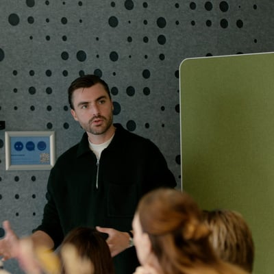 Een man die een presentatie geeft voor een publiek en interactief met de groep communiceert.