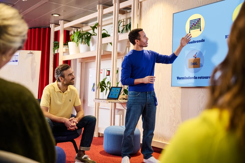 man explaining to group in a colourful space