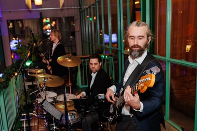 Een band treedt 's avonds op in een zaal.