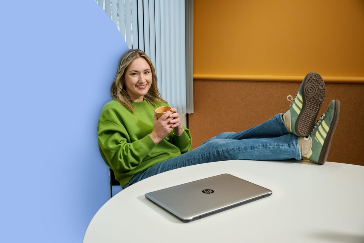 Woman sitting behind closed Macbook