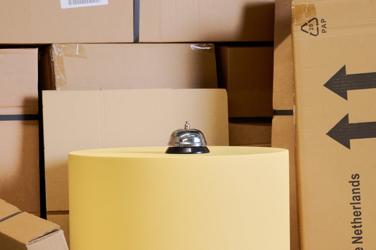 Stacks of brown cardboard boxes with a bell on top.