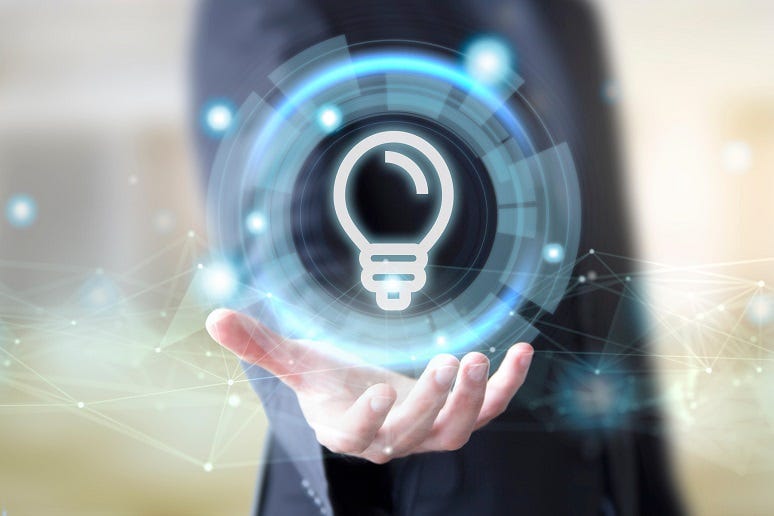 A business person holding a lightbulb icon A business person holding a lightbulb icon