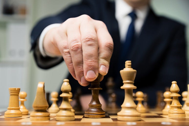 Someone moving chess piece on a board Someone moving chess piece on a board