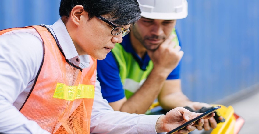 Construction workers review news updates on the phone