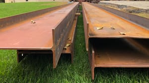 Steel beams laying on green grass Steel beams laying on green grass
