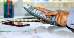 A panoramic picture of a business man pressing a calculator and taking notes of accounting reports, concepts of costing and