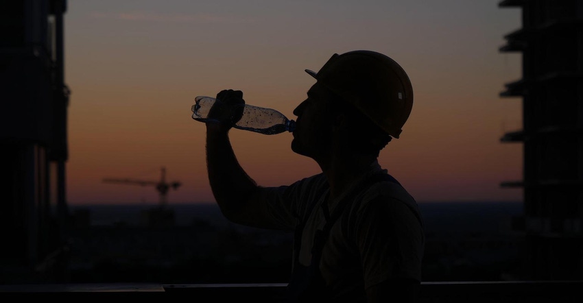 Construction worker drinks water on a hot summer day