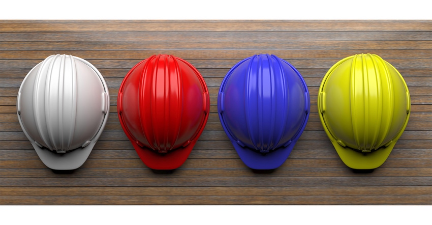 Work safety protection equipment. Industrial protective hardhats on wooden background.