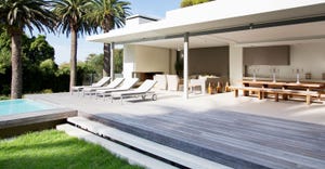 Lounge chairs on ground level deck of modern house