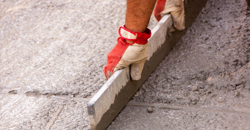 A worker polishes concrete on a flat surface.