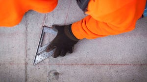Construction worker marking concrete