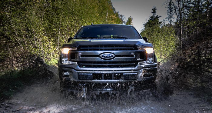 Ford F150 driving in a puddle.