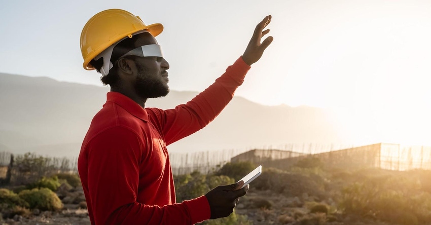 African engineer working with futuristic glasses on construction site - Technology and future industry concept