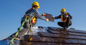 Two roofing contractors working on the roof 