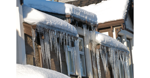 Icicles hanging from the roof of a house in winter