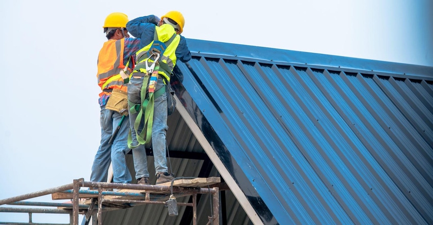 Roofers installing a metal roof