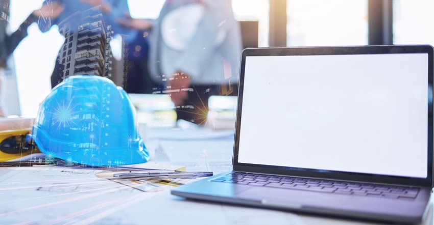 Construction helmet in blue is set on a table next to an open laptop