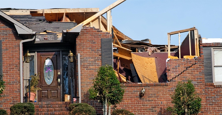 A damaged roof on a brick house