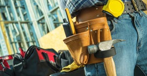 Working Construction Contractor Tools Belt Closeup. Hammer, Measuring Tape and Walkie Talkie.
