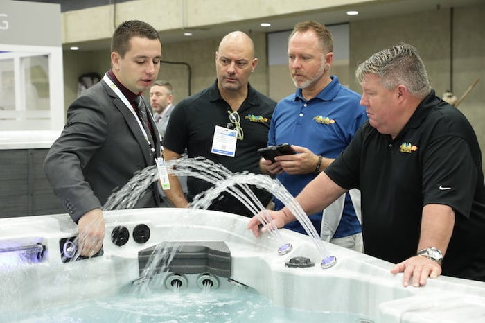 Men gathered around a hot tub for a demonstration 