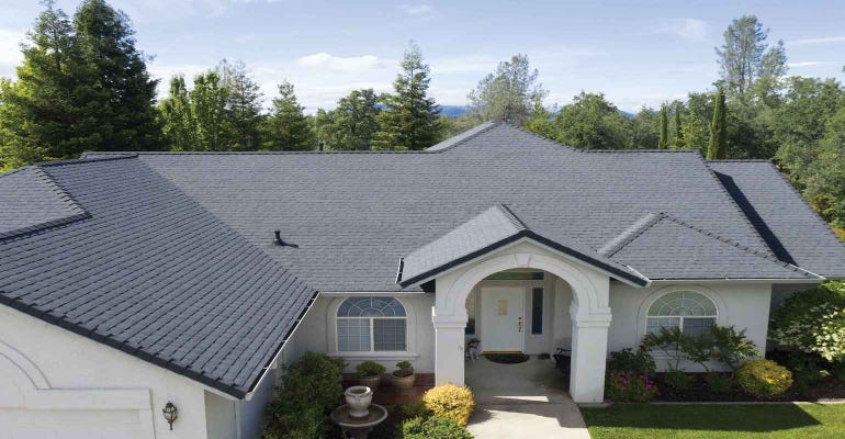 PABCO Premier Radiance Cool Black shingles make up the roof of a white brick home